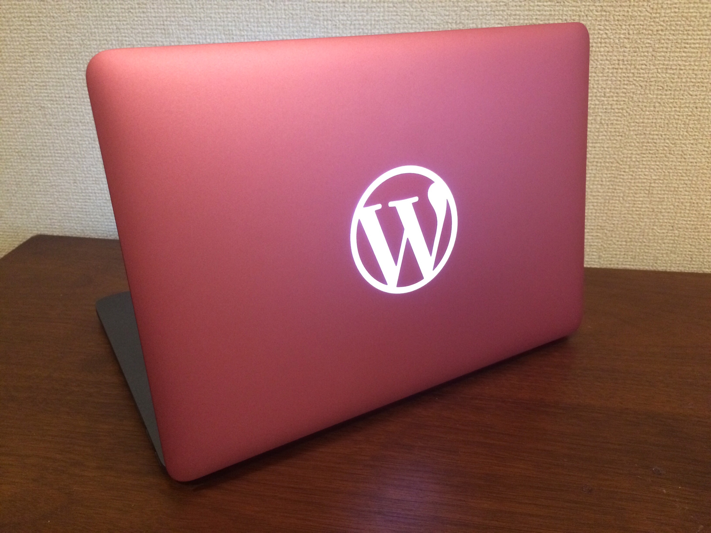 WordPress ロゴ入り、ピンク×グレーの MacBook Pro
